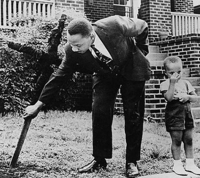 Martin Luther King Jr. retirando una cruz quemada de su jardín delantero en 1960