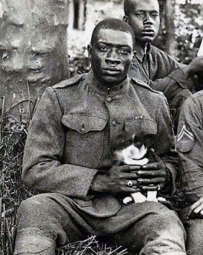 A Member Of The Harlem Hellfighters (369th Infantry Regiment) Poses For The Camera While Holding A Dog That He Saved During The First World War Of 1918