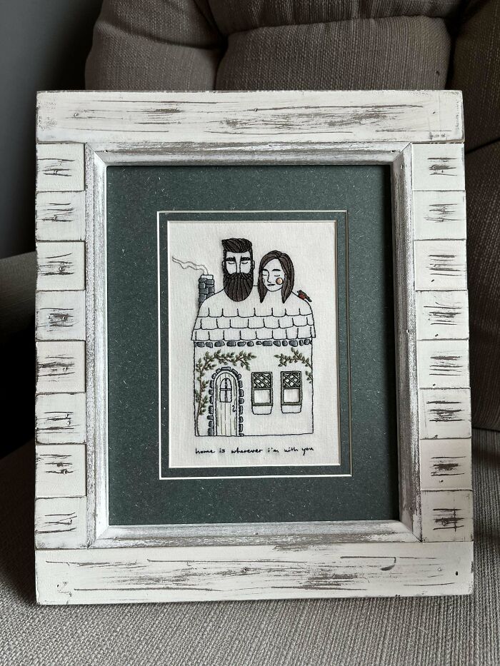 Creative embroidery art of a couple and house in a rustic white frame, featuring intricate handmade details.