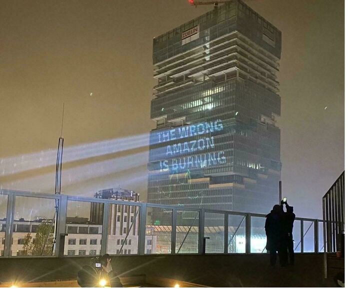 “The Wrong Amazon Is Burning” On The Amazon Tower In Berlin