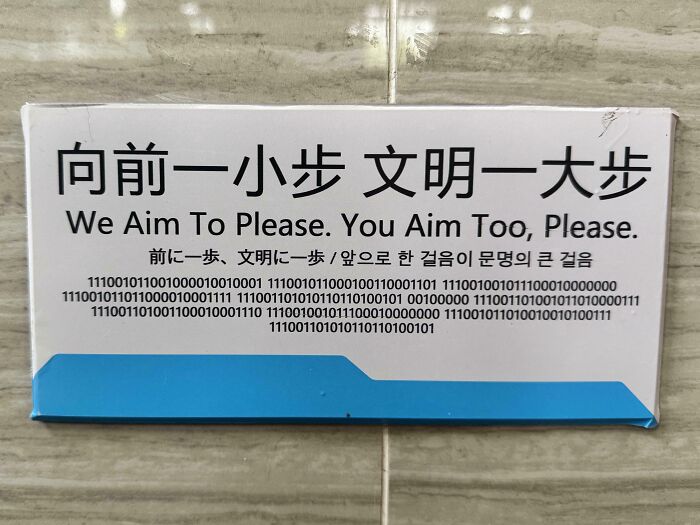 A Sign Over A Urinal In Chinese, English, Japanese, Korean And Binary