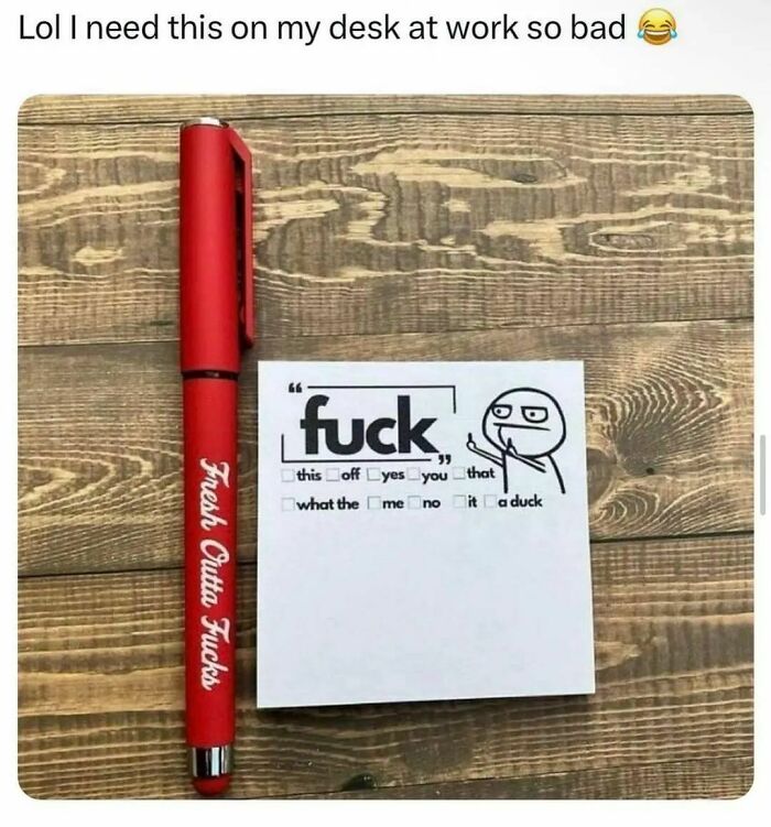 Red pen with "Fresh Outta Fucks" and a humorous checklist paper on a wooden desk.