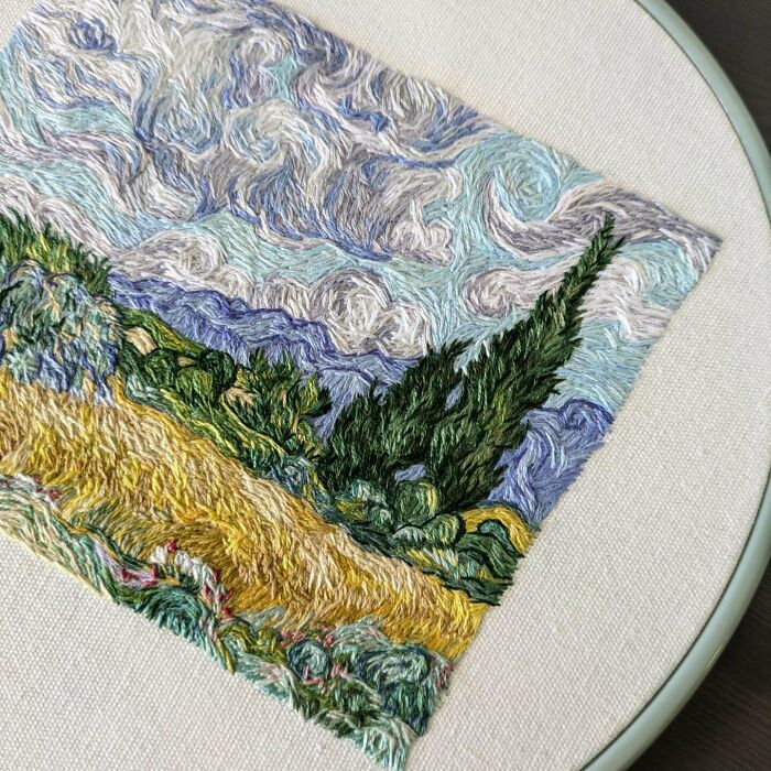 Creative embroidery art depicting a landscape with swirling skies and cypress trees, inspired by Vincent van Gogh.