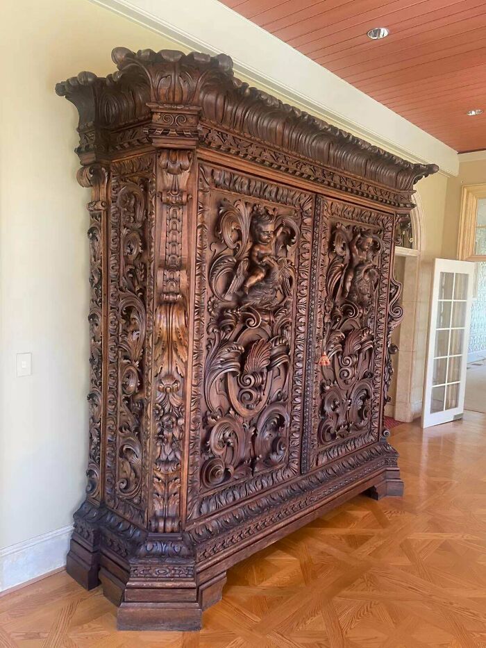 Ornate, large wooden wardrobe showcasing intricate carvings, exemplifying absolute units things.