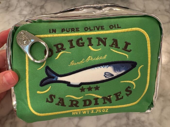 Quirky sardine can purse with a green and yellow design, adding unexpected goofiness to your day.