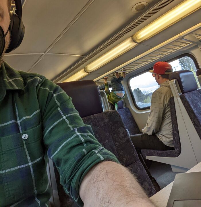 Dad Letting His Kid Climb The Luggage Rack On A Train