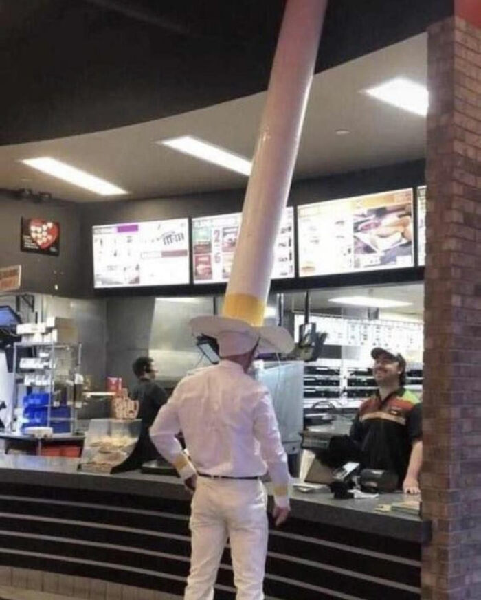 A person in a fast-food restaurant wearing an oversized hat, illustrating the concept of absolute units.