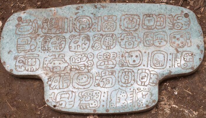 En el yacimiento arqueológico maya de Nim Li Punit, en el sur de Belice, se descubrió un gran colgante en forma de T. Lo que hace notable al colgante de jade es que lleva inscrito un texto histórico compuesto por 30 jeroglíficos.