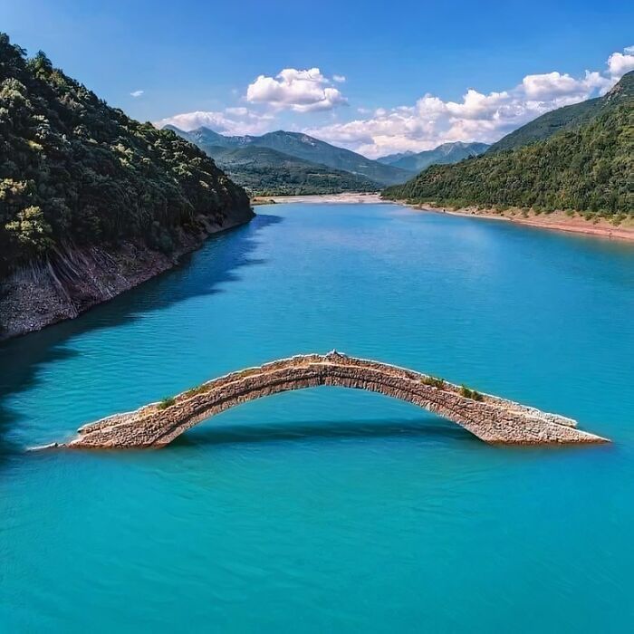 The Stone Bridge Of Manolis Over Agrafiotis River In Greece. The Bridge Is Almost All Year Underwater And Only Part Of Its Arch May Be Visible, Except The Summer Months When The Water Level Drop