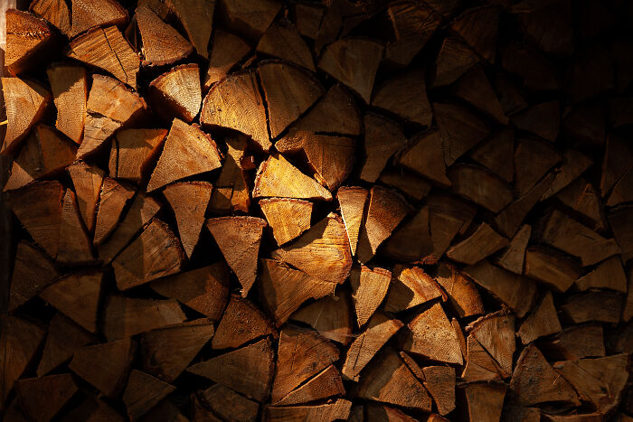 Light Play On Wood | Light Filtering Between Two Boards Under A Porch Onto A Stack Of Chopped Wood