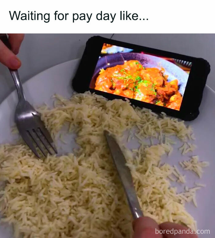 Meme of the day: The image shows a plate with plain rice, and a person is holding a fork and knife, pretending to eat. In the background, a phone is propped up displaying a picture of a delicious meal. The text above the image reads, "Waiting for pay day like..." humorously depicting the struggle of eating simple food while imagining something much more appetizing until payday arrives.