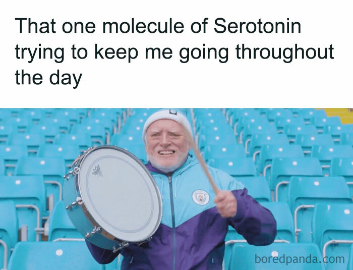 A "You can do it" meme showing an older man in a Manchester City jacket enthusiastically playing a drum in an empty stadium. The text above the image reads, "That one molecule of Serotonin trying to keep me going throughout the day." The man's expression and effort are intended to humorously represent the minimal energy or motivation trying to sustain someone through the day.