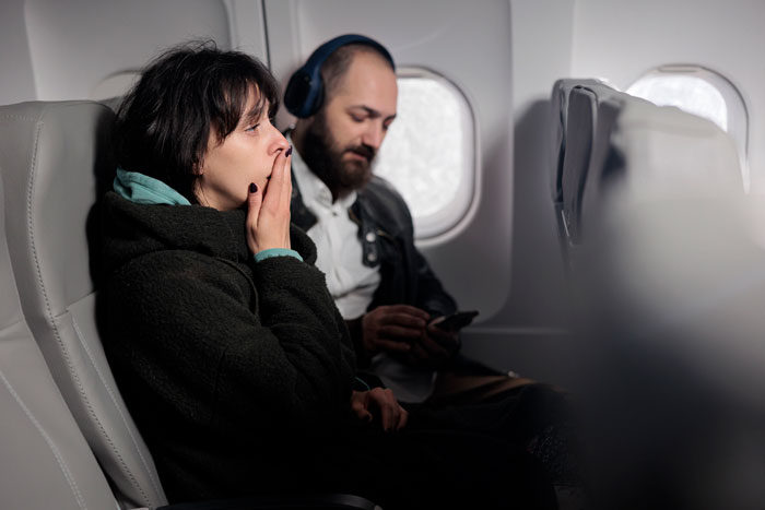 Lady Sandwiched Between Couple On Long Flight Has To Endure Woman’s Obnoxious Behavior For 5 Hours