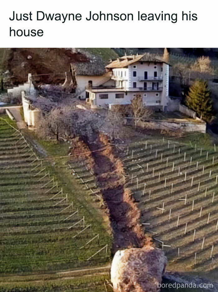 A The Rock meme showing an aerial view of a large house with a huge boulder that has rolled down the hillside, leaving a trail of destruction in its path. The text above reads, "Just Dwayne Johnson leaving his house," humorously suggesting that the massive boulder symbolizes The Rock leaving his home with his typical unstoppable force, playing on his name and persona.