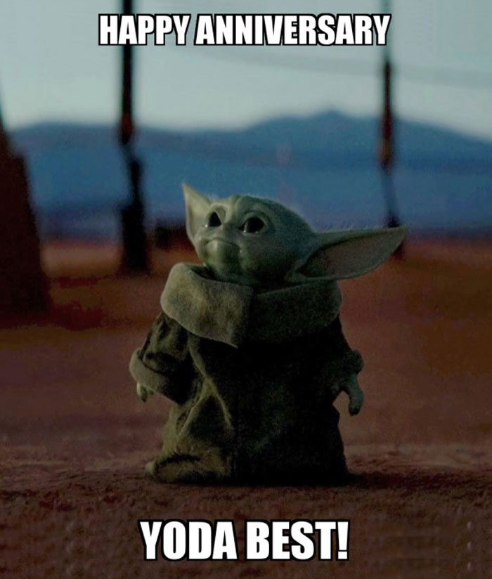 A work anniversary meme featuring a character resembling Baby Yoda from the Star Wars series. The character is standing in a dimly lit environment, looking cute and content. The text above the image reads, "HAPPY ANNIVERSARY," and the text below says, "YODA BEST!" The meme humorously plays on the words "Yoda" and "You're the best," to celebrate someone's work anniversary in a playful and endearing way.