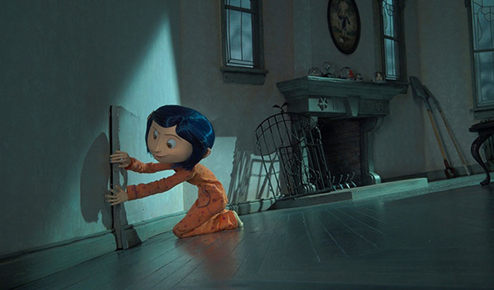 A scene from the movie Coraline featuring a young girl with blue hair, wearing orange pajamas, kneeling on the floor in a dimly lit room. She is opening a small door in the wall, peeking inside with curiosity. The room is sparsely furnished with a fireplace and old tools, creating an eerie and mysterious atmosphere. Sunlight streams through the windows, casting shadows that enhance the sense of intrigue and adventure.