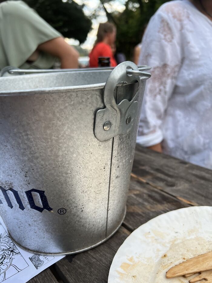 Un cubo de cerveza con un abridor de botellas en el costado