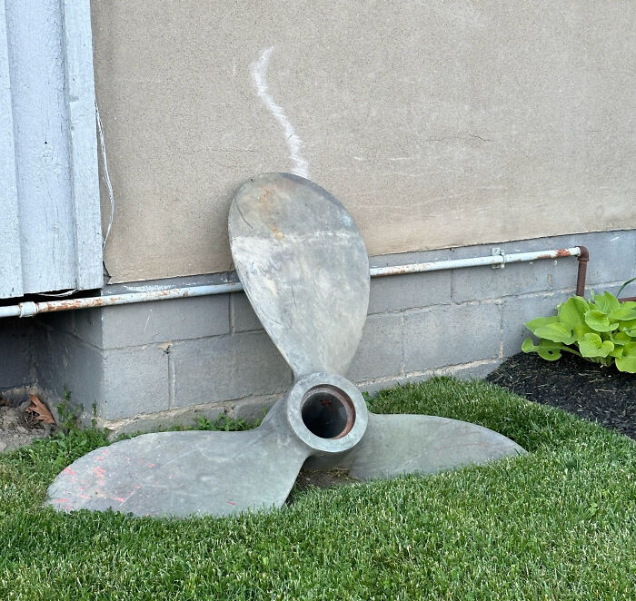 A Heavy Ship Propeller Sinking Into The Soil Over Years And Leaving Its Mark On The Wall