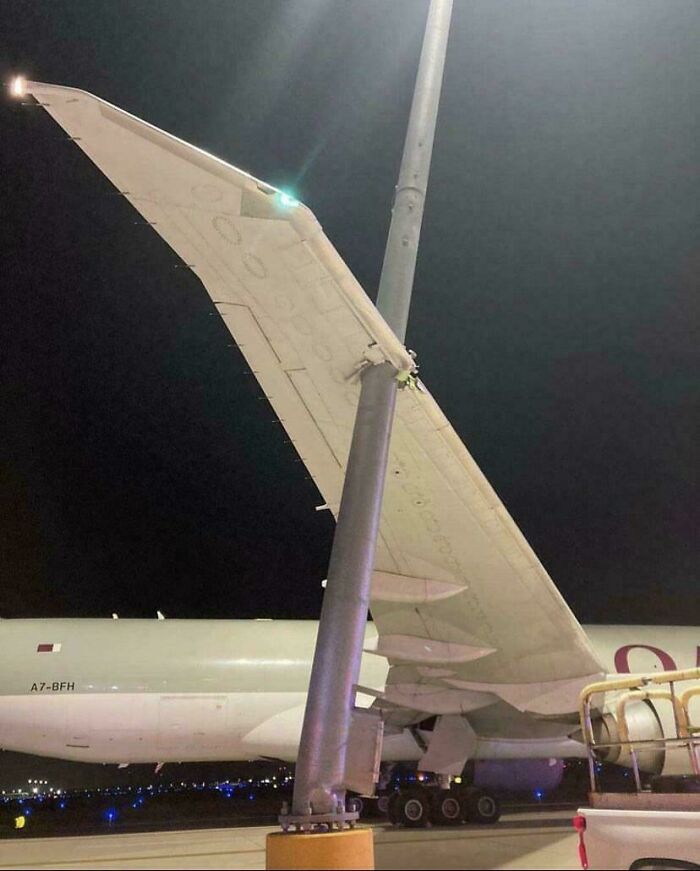 Airplane wing struck by a light pole, illustrating an unfortunate incident that looks expensive.