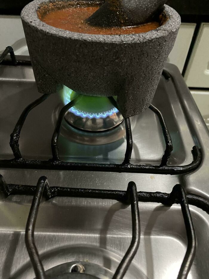 Molcajete on stove with sauce simmering, showcasing mildly interesting cooking technique.