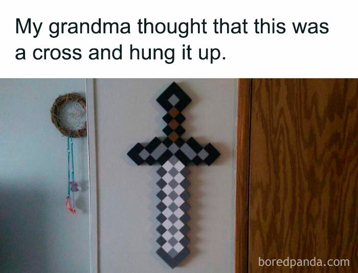 A Minecraft meme featuring a photo of a pixelated Minecraft sword hung vertically on a wall. The text above reads, "My grandma thought that this was a cross and hung it up," humorously suggesting that the person's grandmother mistook the iconic Minecraft sword shape for a religious cross and decided to display it on the wall, not realizing it was actually a gaming reference.