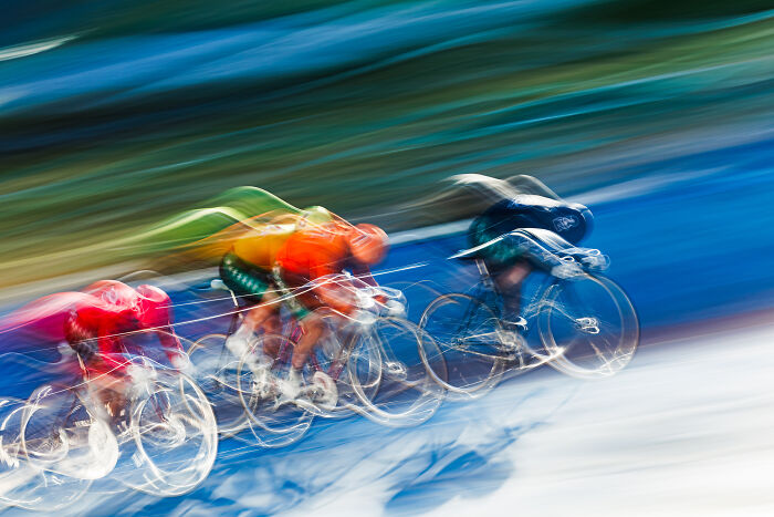 Blurred cyclists in dynamic motion capture, showcasing innovative photography techniques at the 2024 IPA.