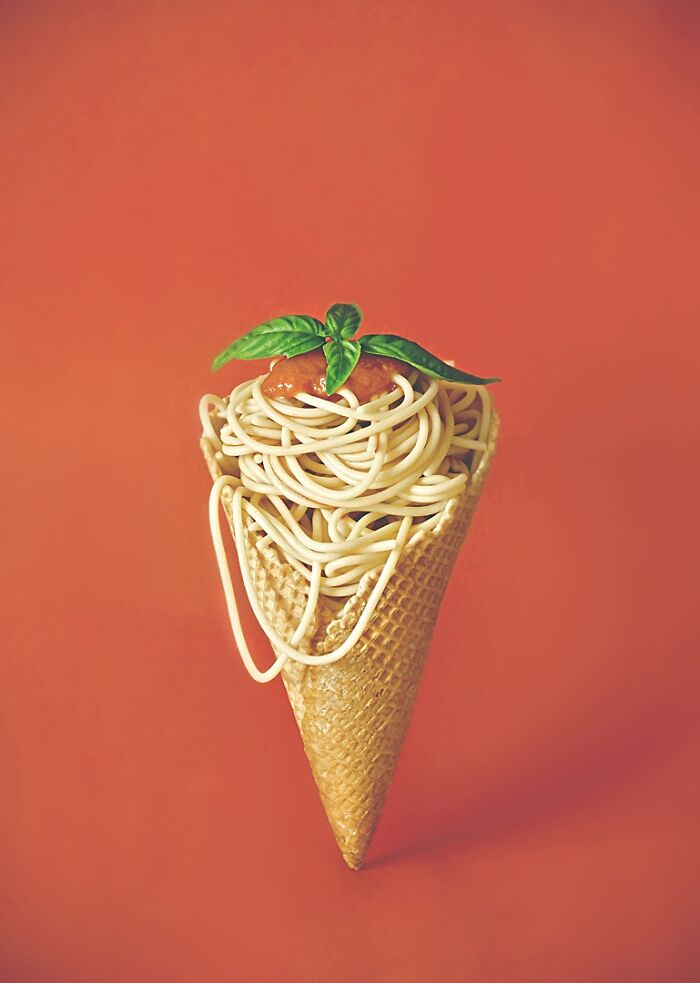 Creative advertising photo: spaghetti in a waffle cone with basil and tomato sauce, from 2023 Budapest Foto Awards.