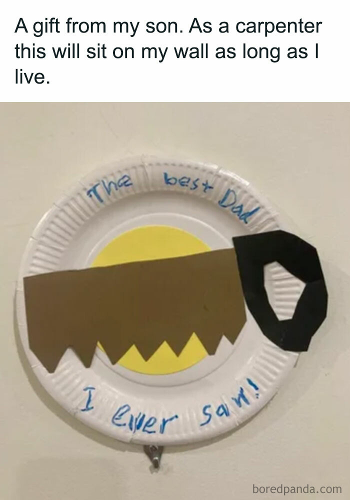 A Dad meme featuring a heartfelt yet humorous craft gift from a son to his carpenter father. The text above the image reads, "A gift from my son. As a carpenter, this will sit on my wall as long as I live." Below, there is a photo of a paper plate with a handmade decoration resembling a saw, crafted from colored paper. The plate is labeled in a child's handwriting, "The best Dad I ever saw!" The meme humorously combines a pun on the word "saw" with a touching expression of love and admiration from a son to his father.