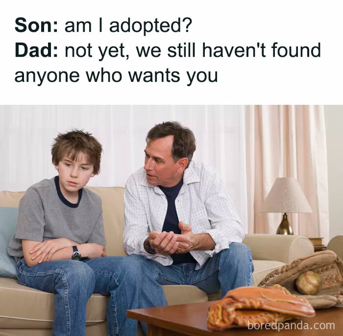  A Dad meme featuring a humorous conversation between a father and his son. The text reads, "Son: am I adopted? Dad: not yet, we still haven't found anyone who wants you." Below the text is an image of a dad sitting on a couch, looking at his son with a serious expression while the son sits next to him, looking confused or concerned. The meme plays on the classic dad joke style of humor, delivering a playful and sarcastic response to the son's innocent question.