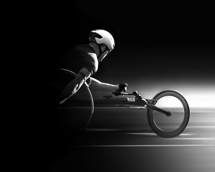 Athlete in a wheelchair racer wearing a helmet, captured in dynamic motion, winner at Tokyo International Foto Awards 2023.