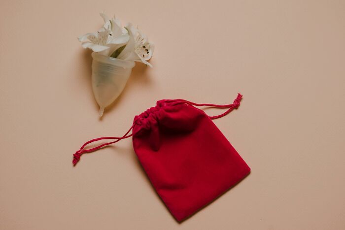 Red pouch and a menstrual cup with flowers.