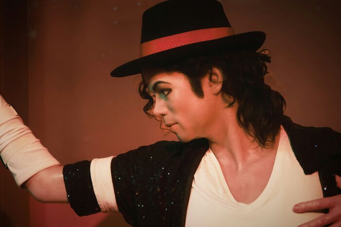 Michael Jackson in a fedora and sequined jacket striking a dance pose, embodying a hilariously inaccurate fact someone told.