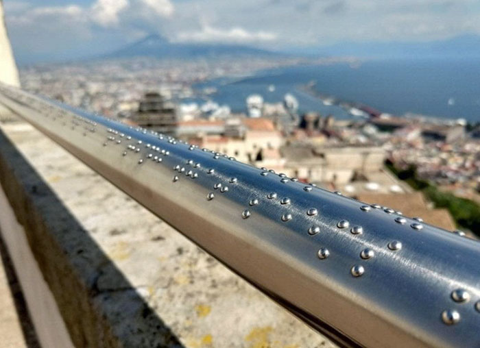 Esta barandilla en un cenador de Nápoles tiene una descripción en braille de las vistas, para los invidentes. Más de esto, por favor