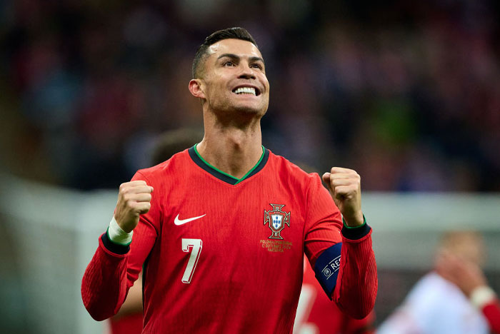 Cristiano Ronaldo, wearing a red Portugal jersey with number 7, celebrates with clenched fists.