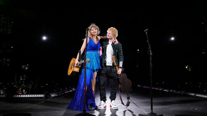 Taylor Swift and Ed Sheeran performing on stage together, with Taylor Swift in a blue dress and holding a guitar. How tall is Taylor Swift?