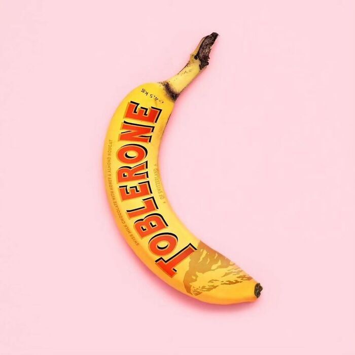 A surreal banana with Toblerone packaging on a pink background, reflecting surrealism-world themes.