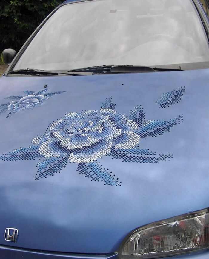 Blue car hood with cross-stitch flower design, showcasing an adorable and weird artistic style on Instagram.