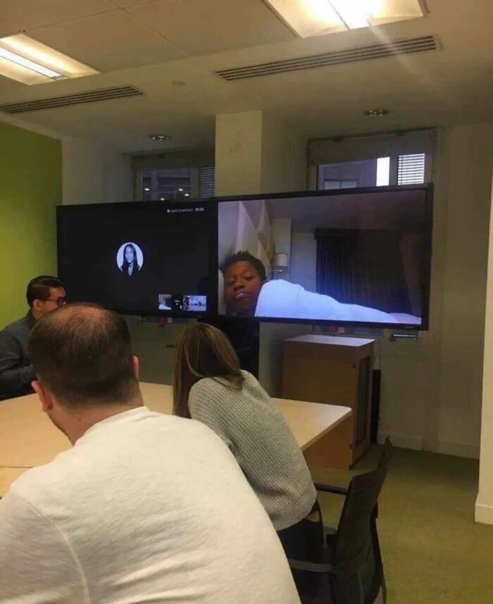 Group video call in a meeting room featuring an unusual display setup, capturing an adorable-weird moment.