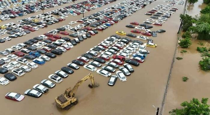 Flooded parking lot with submerged cars, highlighting an expensive incident likely costing a fortune.