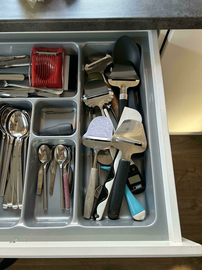 Drawer filled with various cheese slicers and kitchen utensils, a mildly interesting and quirky collection.