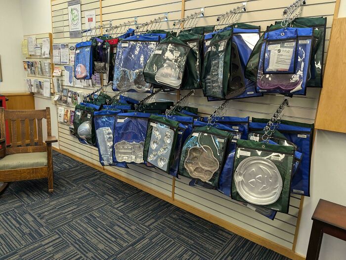 Wall display of various cake pans in protective bags, showcasing a mildly interesting store setup.