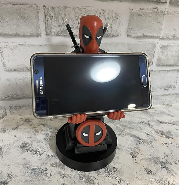 Your Phone's About To Get A Superhero Sidekick (Who's Also A Little Bit Of A Jerk). This Deadpool Phone Holder Will Keep Your Device Safe And Sound 