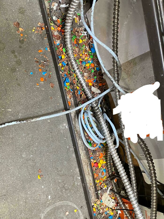 Colorful confetti mixed with cables on a concrete floor, capturing a mildly interesting scene.