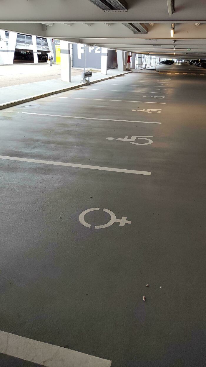 Accessible parking spots marked with gender symbols in a mildly interesting parking garage.