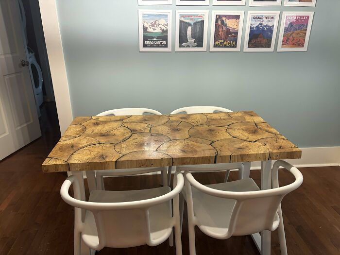 Woodworking project featuring a unique wooden table with white chairs in a dining room setting.