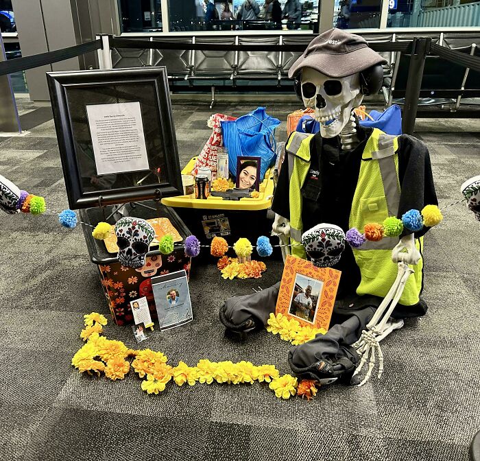 Mildly interesting skeleton display with colorful decorations and framed photos in a public setting.