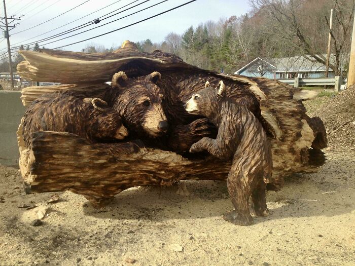 Woodworking project depicting bears sculpted into a wooden log on a roadside, showcasing impressive craftsmanship.