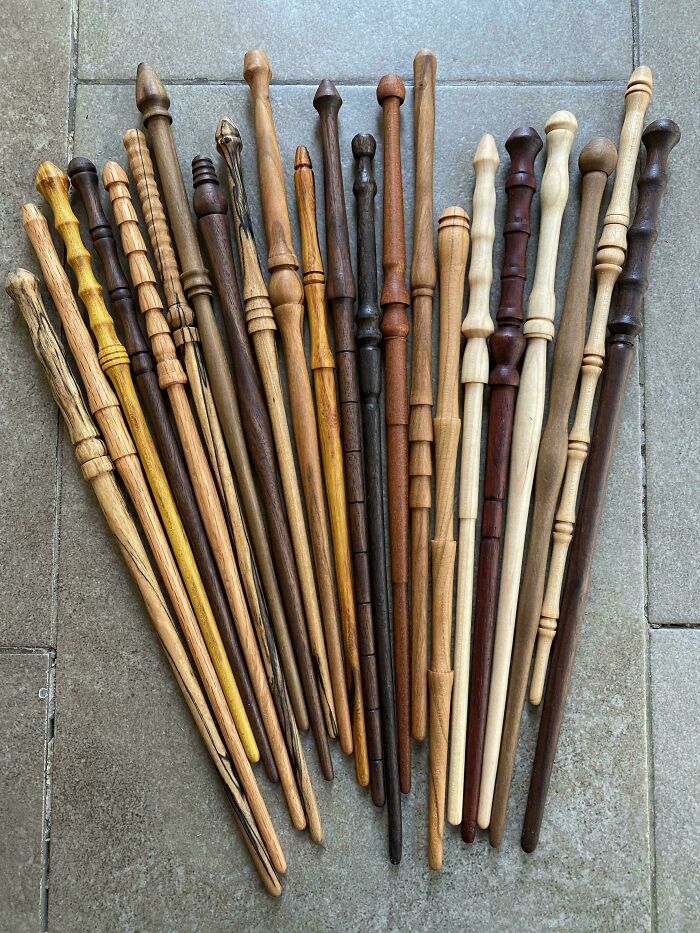 A variety of handmade wooden wands showcasing impressive woodworking projects on a tiled surface.