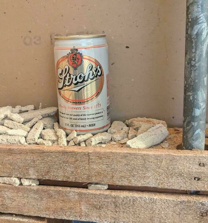 Stroh's beer can found inside a wall among rubble, an example of something mildly interesting.