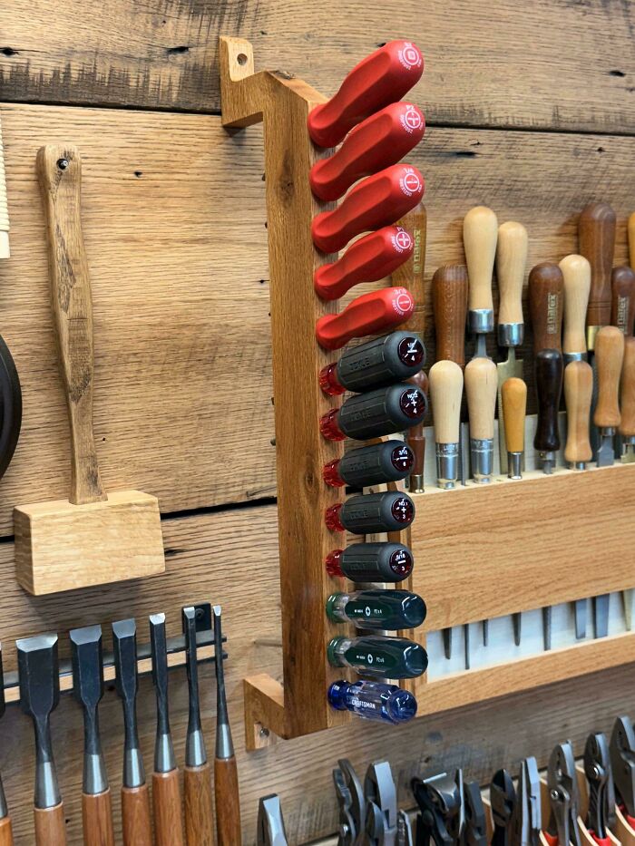 Woodworking projects display featuring a tool organizer with chisels and screwdrivers on a wooden wall.